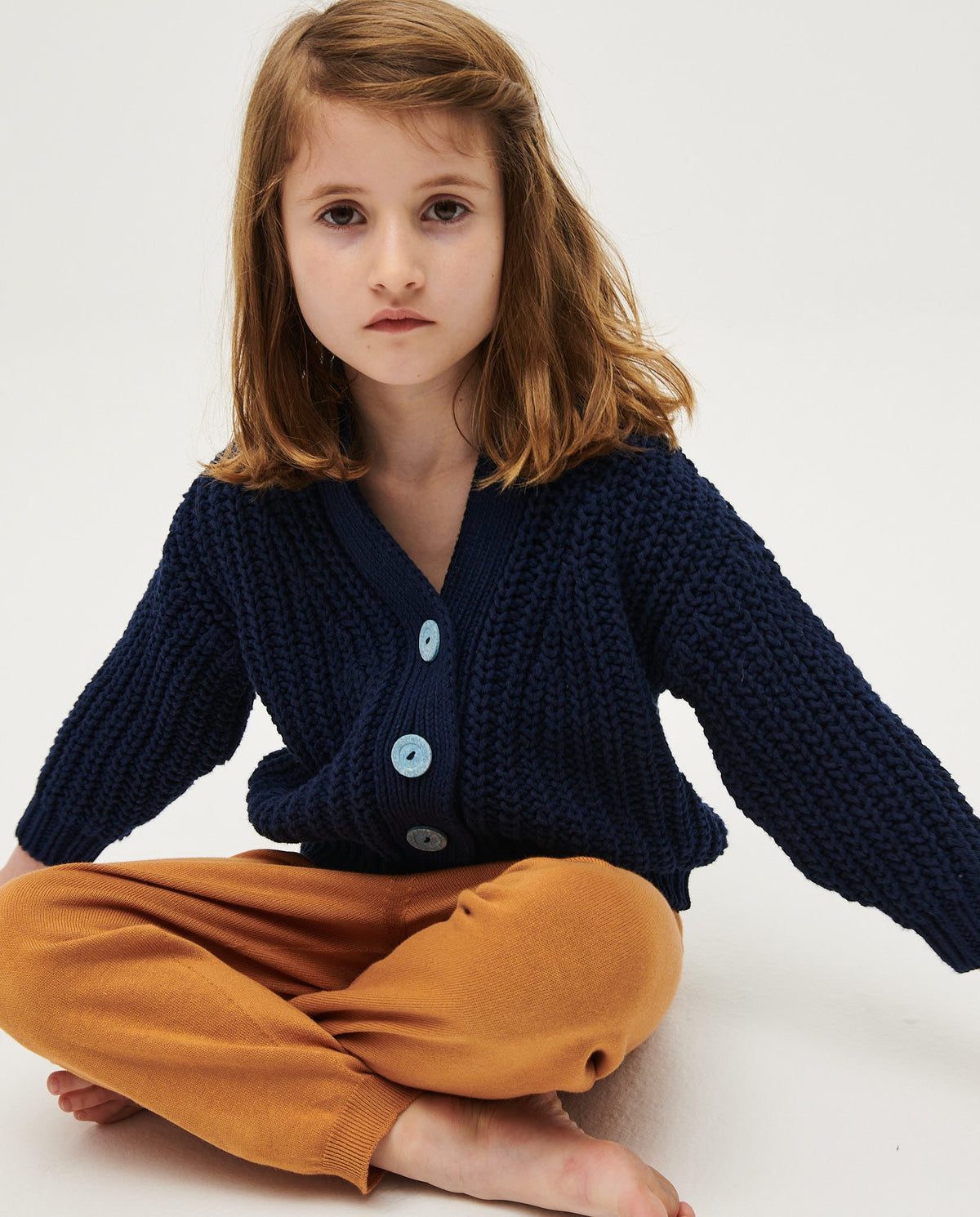 Navy kids' cardigan from Babaà with button details, soft knit fabric, and classic style, shown on a hanger.