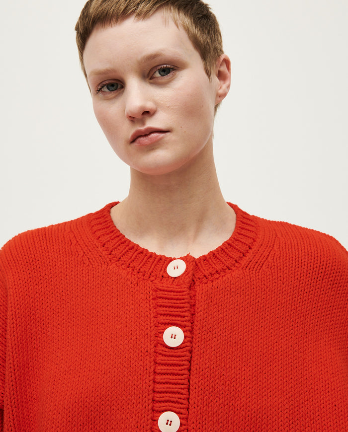 Babaà No14 Summer Flame women's cardigan in vibrant orange with knit detail, worn open over a casual outfit.