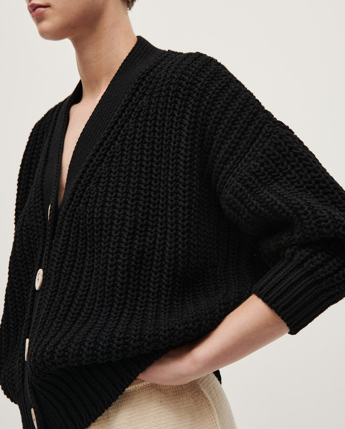 Black Babaà No18 women's cardigan displayed on a hanger with a soft, cozy knit texture and a relaxed fit.