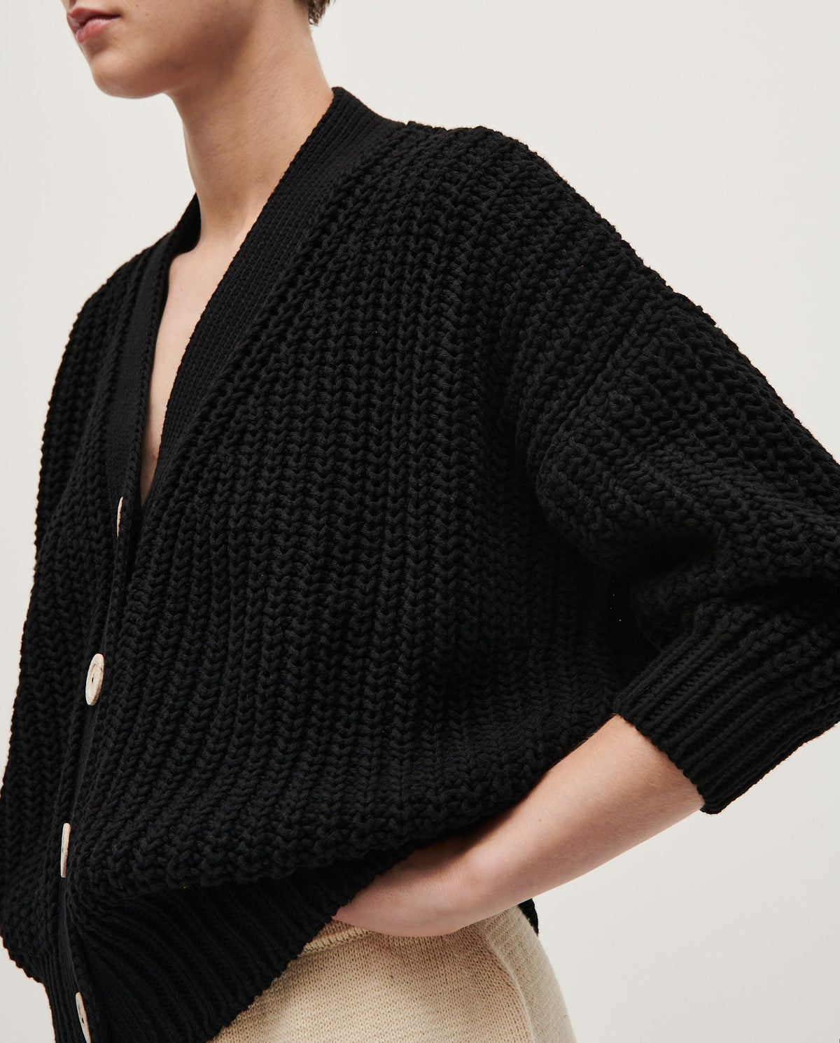 Black Babaà No18 women's cardigan displayed on a hanger with a soft, cozy knit texture and a relaxed fit.