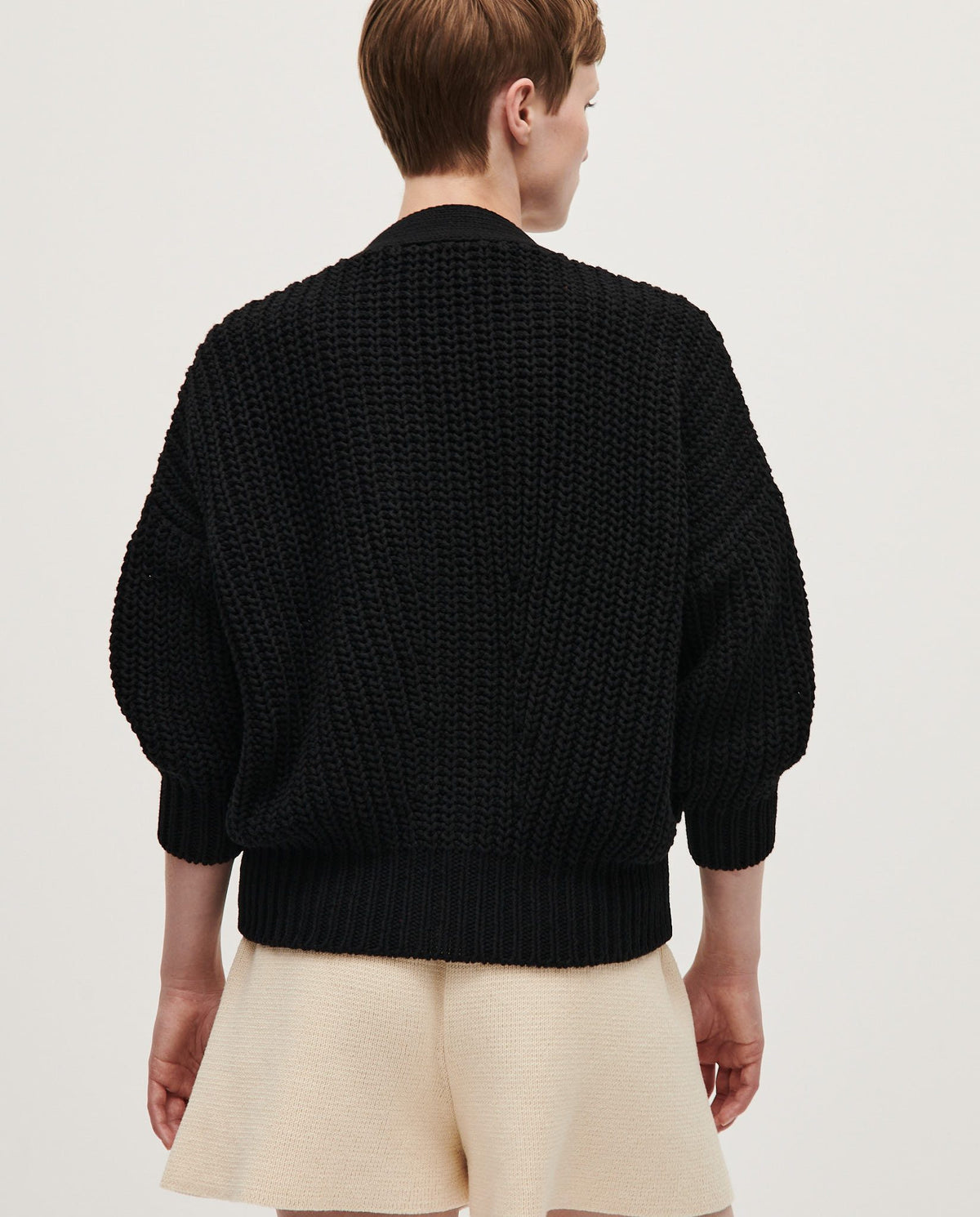 Black Babaà No18 women's cardigan draped on a mannequin, showcasing its soft knit fabric and relaxed fit.