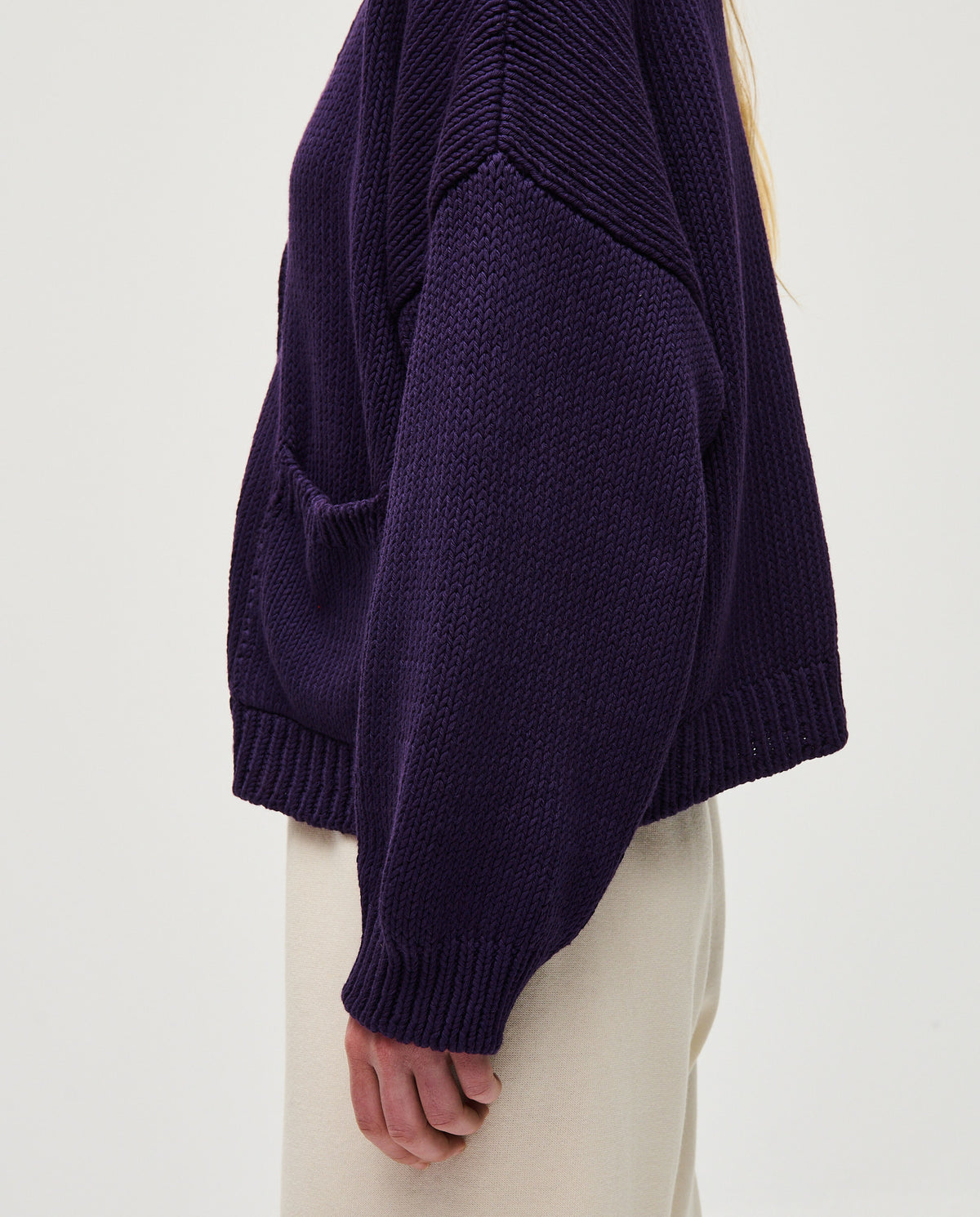 Woman wearing Babaà No22 Ridge cardigan, soft knit with textured pattern, featuring a relaxed fit and button closure.