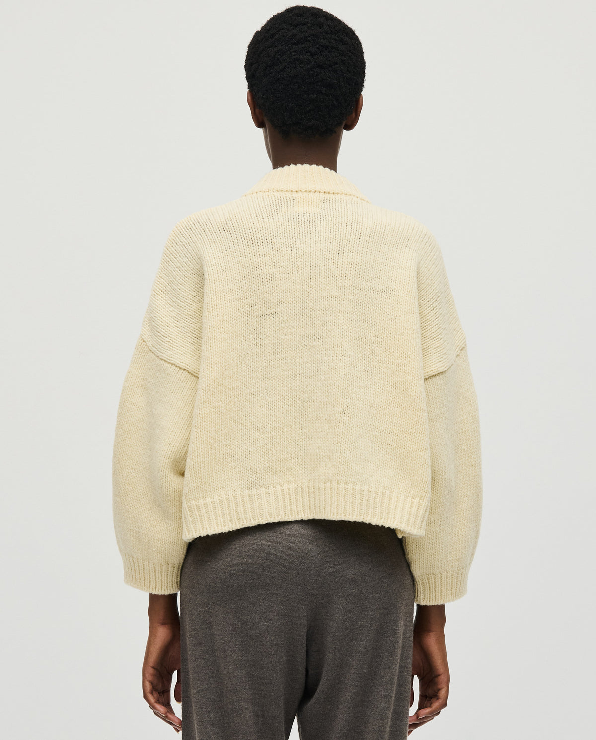 Babaà No23 natural women's cardigan displayed on a hanger, featuring a soft, neutral-colored knit fabric with button closure.