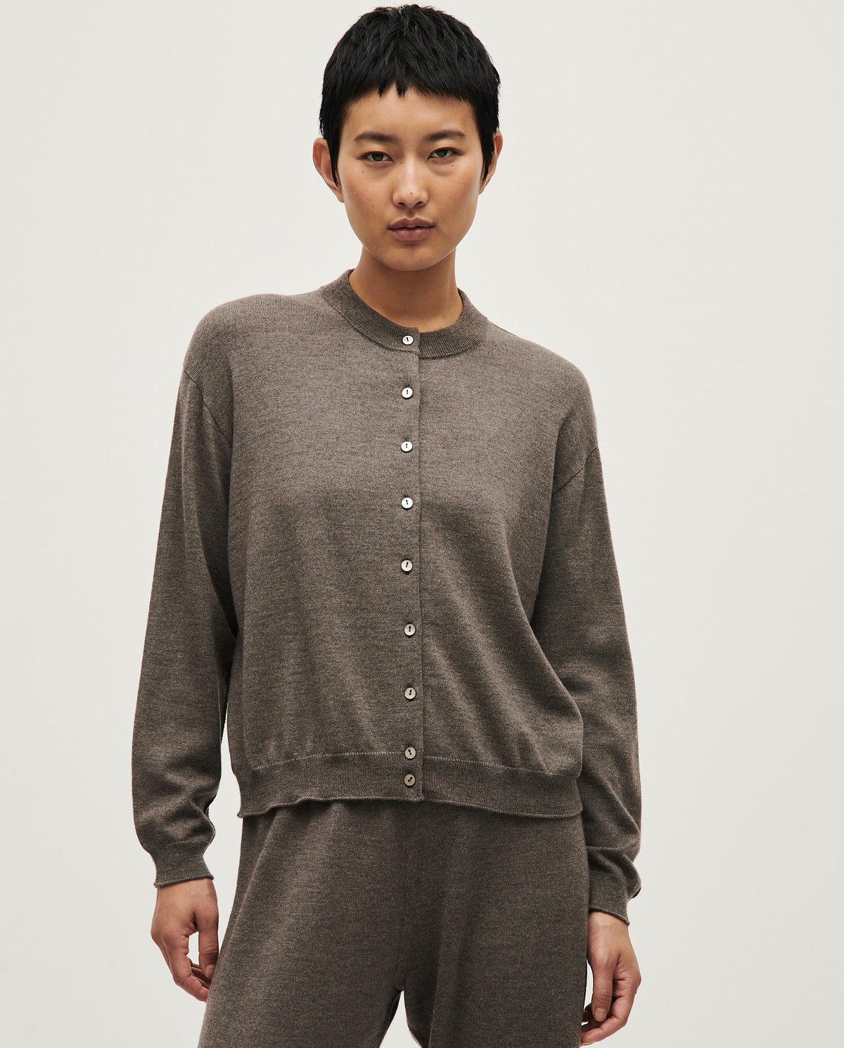 Woman wearing Babaà No25 Volcán cardigan, soft knit with earthy tones, displayed on a model in a casual setting.