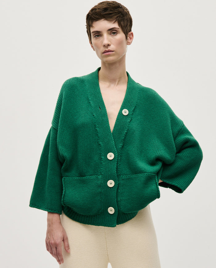 Woman wearing Babaà No26 Tree Fern cardigan featuring a cozy knit with green and beige tree fern pattern.