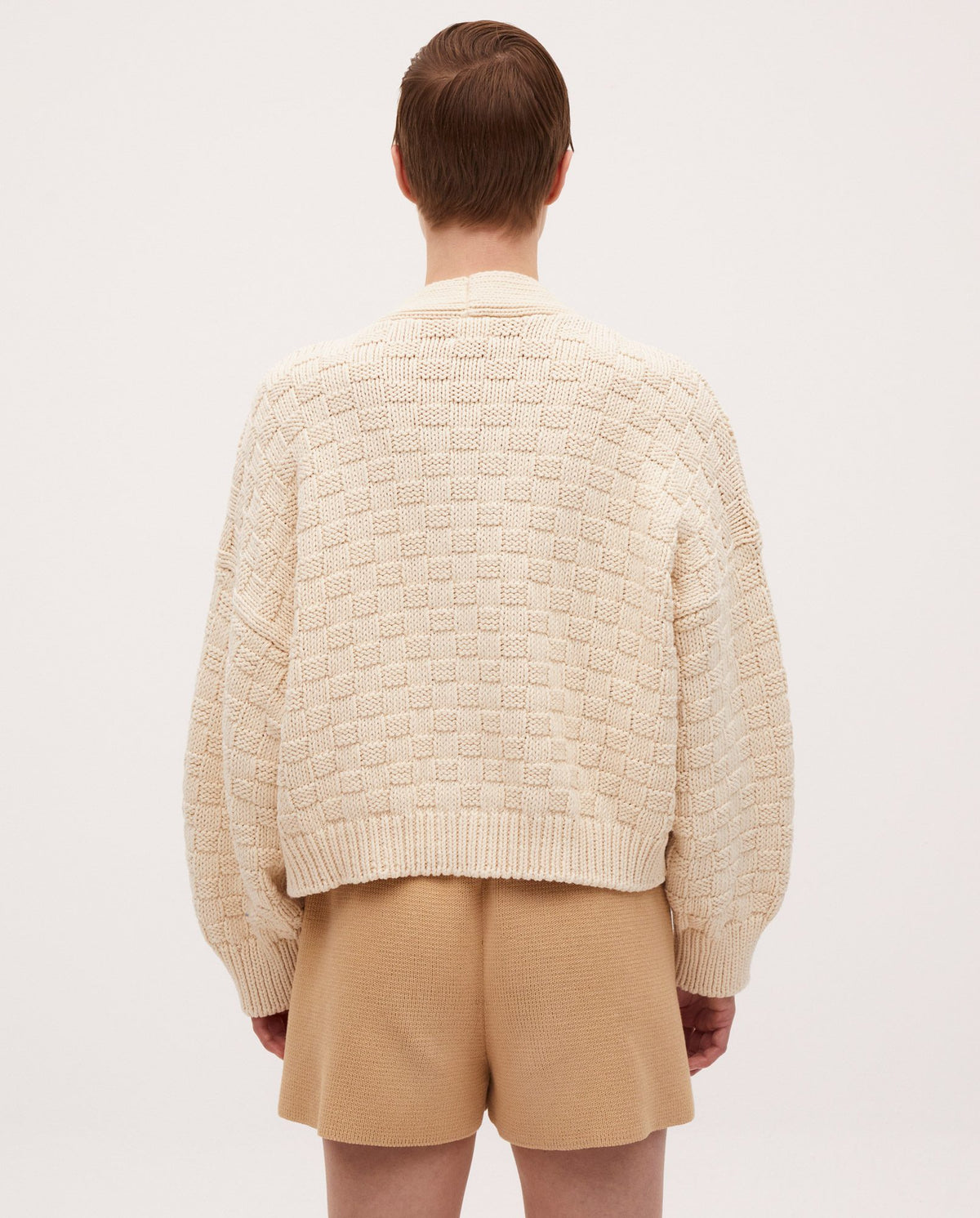 Woman wearing Babaà No3 Natural cardigan, soft knit with long sleeves and open front, in a neutral beige color.