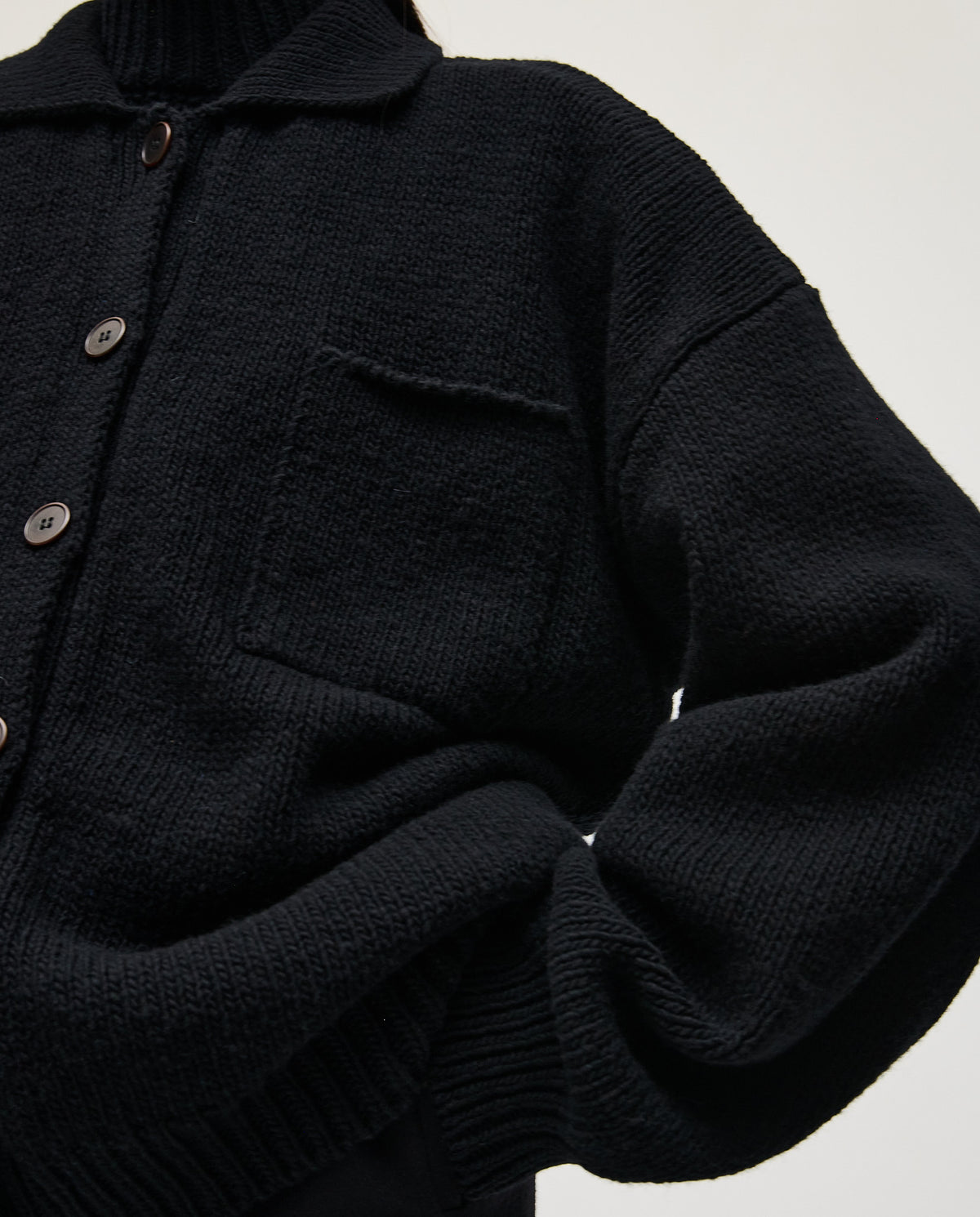 Black Babaà No93 women's cardigan displayed on a hanger with a soft knit texture and classic design.