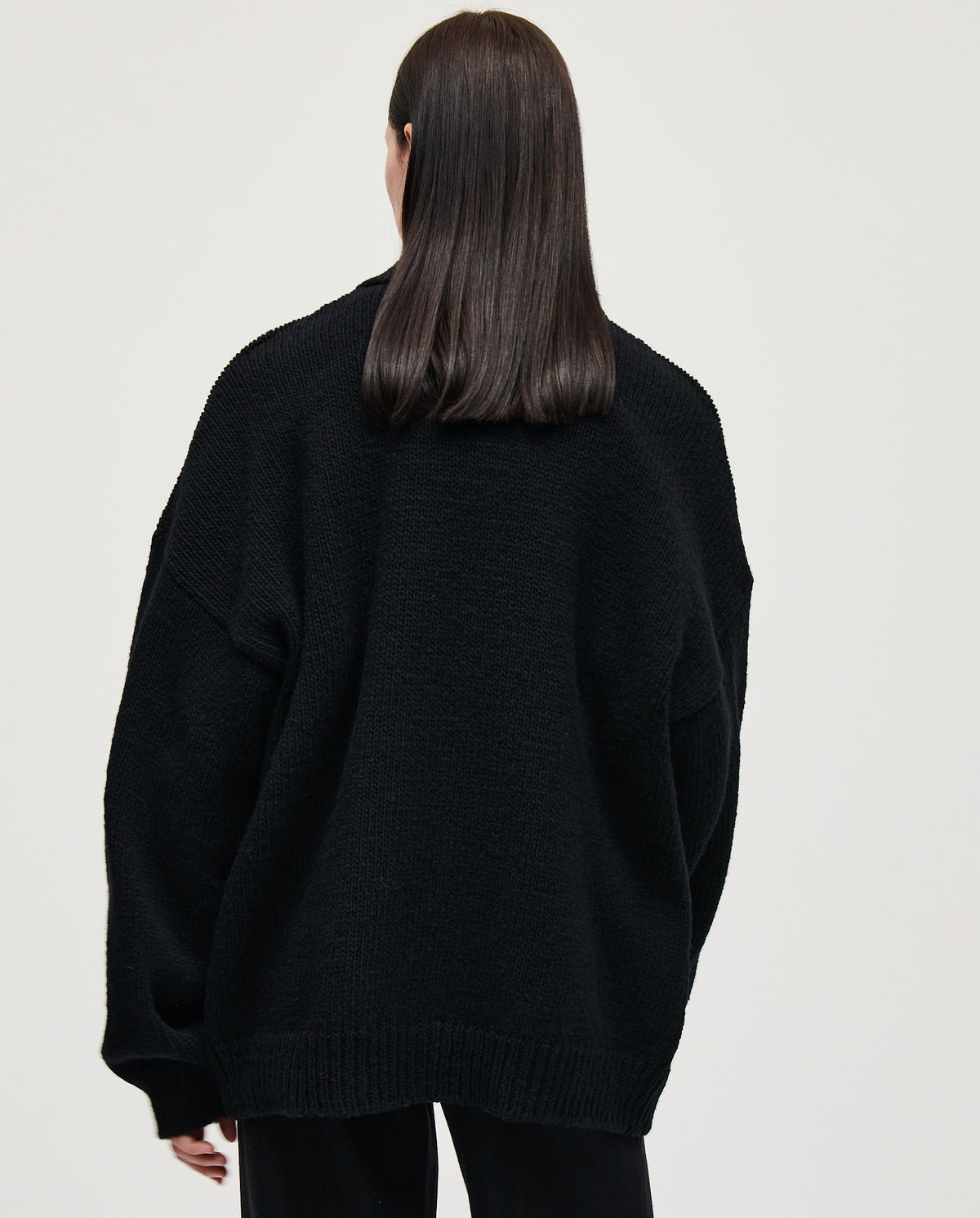 Black women's Babaà No93 cardigan displayed on a hanger, showcasing its soft fabric and relaxed fit.