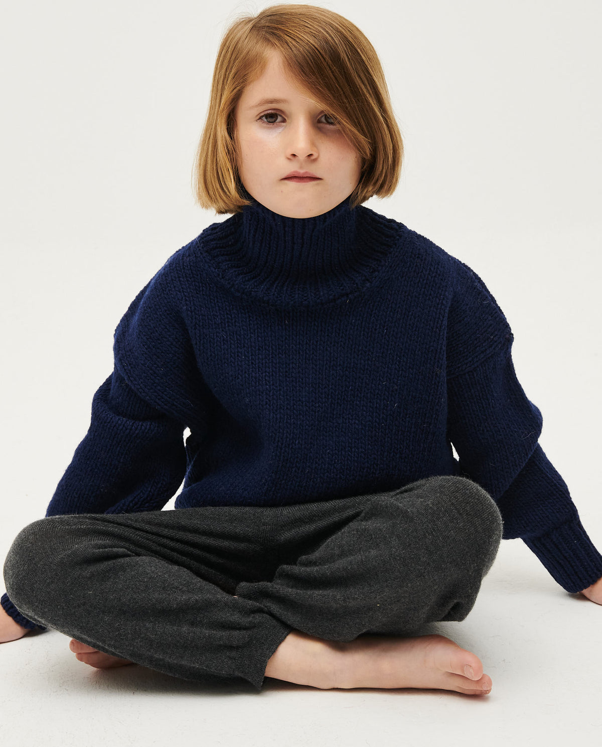Navy kids' jumper No17 by Babaà, displayed on a hanger with a soft knit texture and ribbed cuffs.