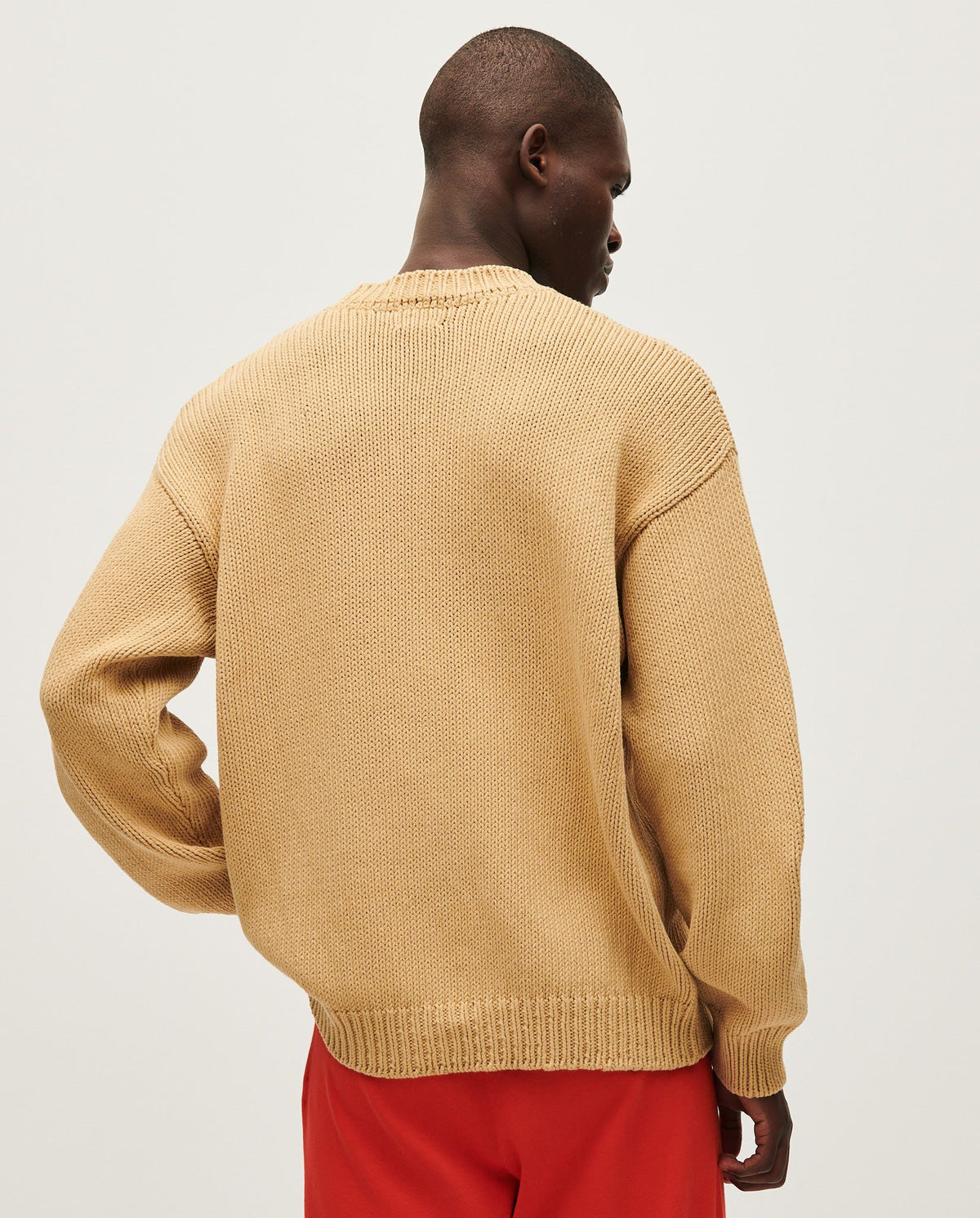 Man wearing Babaà No16 jumper with a clay pot, showcasing casual style and comfortable knitwear.