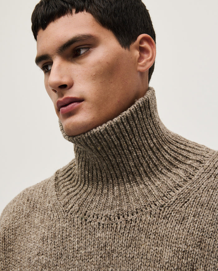 Man wearing Babaà No17 Dark Mist jumper, showcasing the casual fit and cozy knit fabric in a natural outdoor setting.