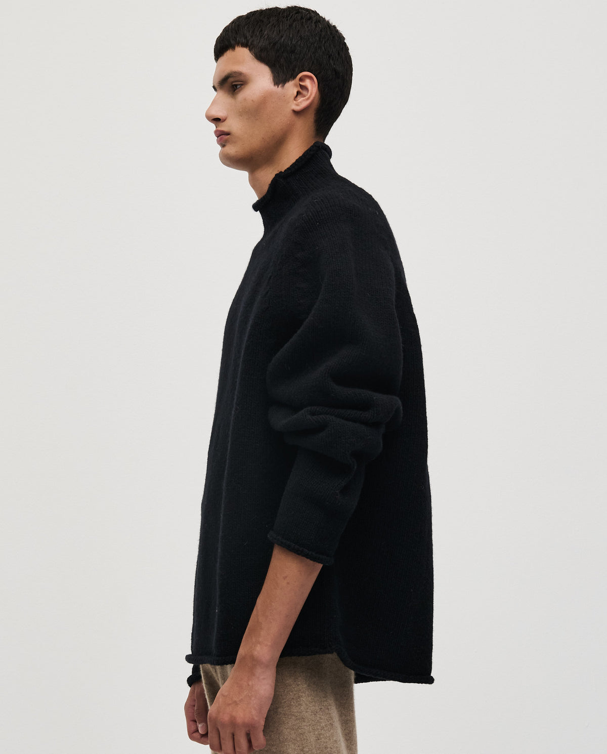 Black Babaà No81 men's jumper displayed on a hanger, showcasing its classic fit and knit texture.