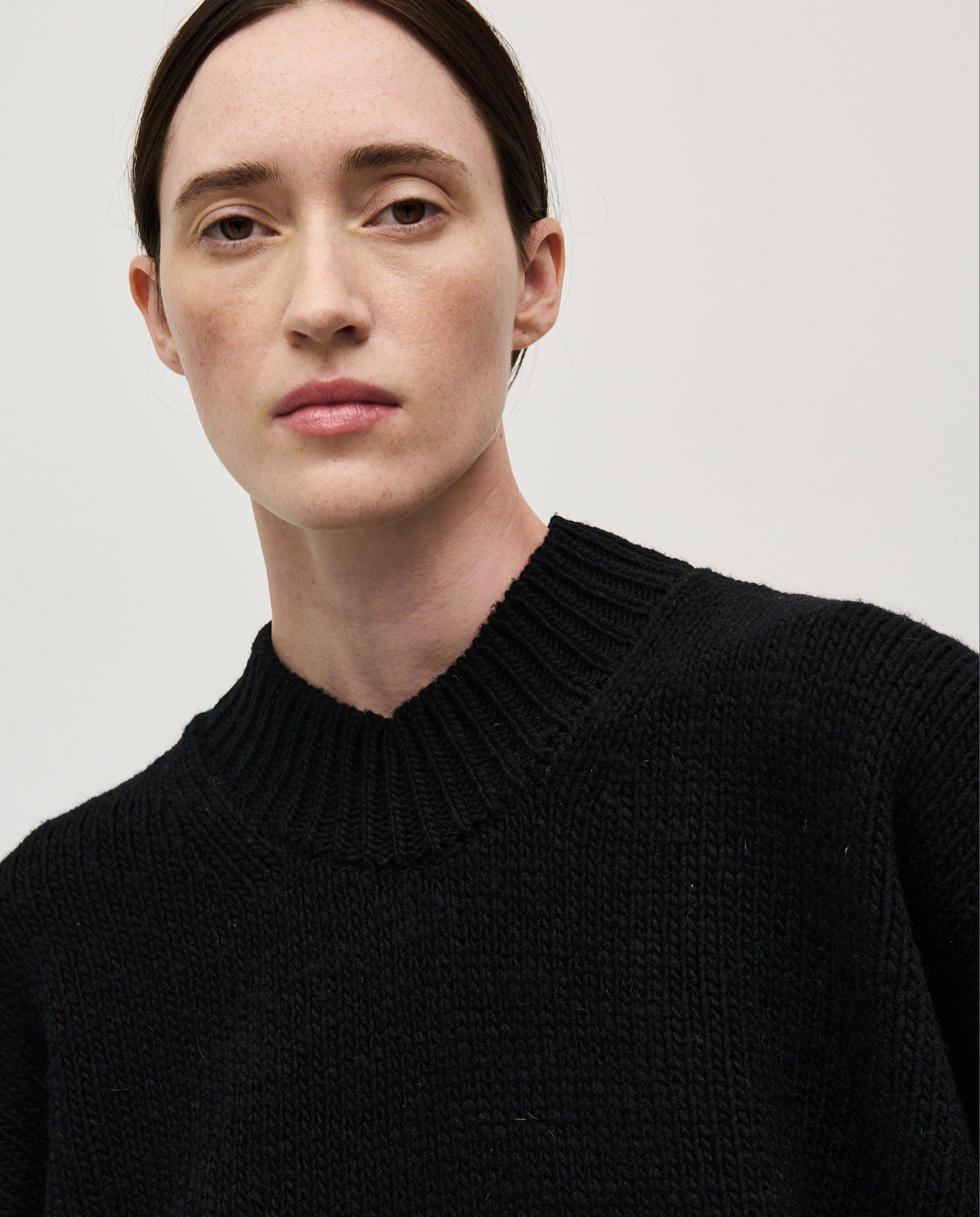 Black Babaà Jumper No11 worn by a woman, showcasing a cozy, stylish knit sweater with a relaxed fit and ribbed cuffs.