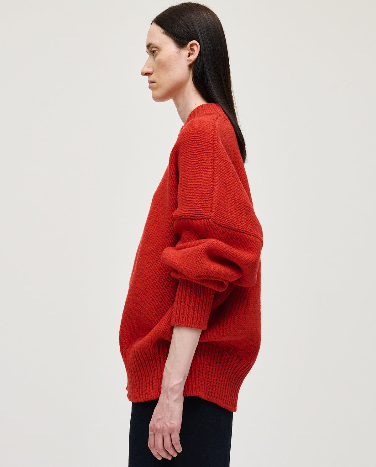 Red Babaà jumper No11 worn by a woman, featuring a cozy knit design and relaxed fit.