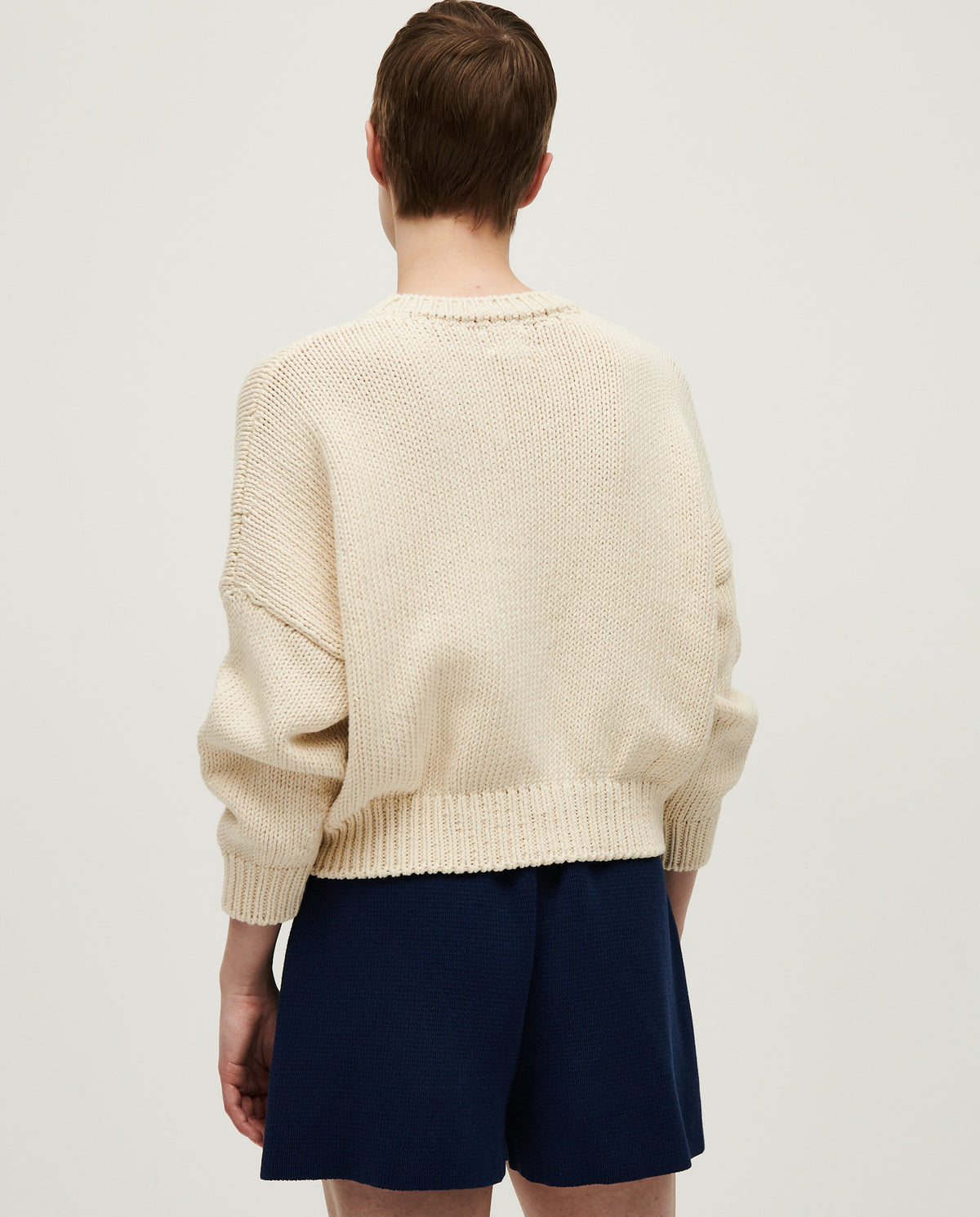 Woman wearing Babaà No14 Natural jumper, cozy knit sweater in soft beige with a relaxed fit and long sleeves.