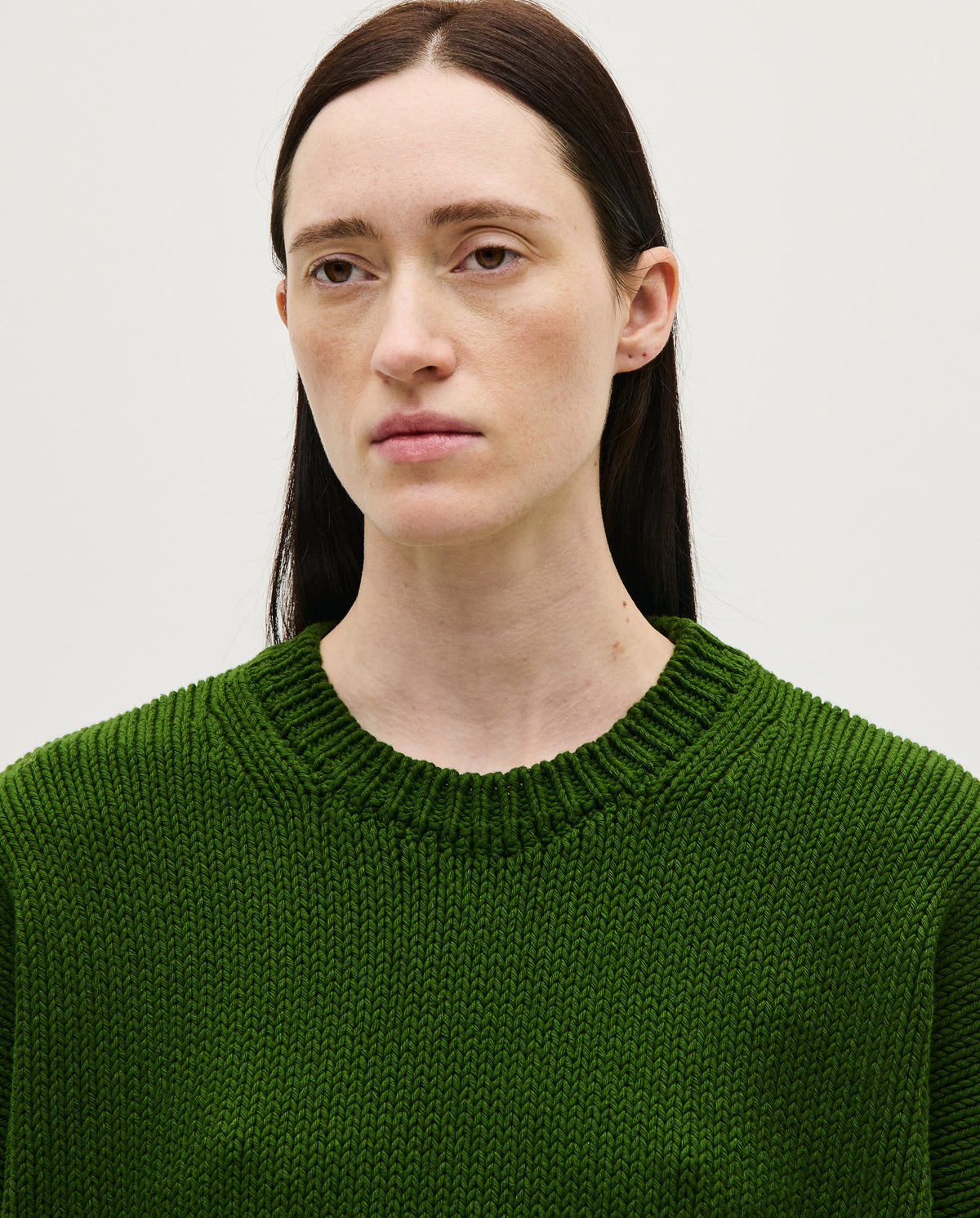 Woman wearing Babaà No14 Pine jumper, showcasing the cozy knit sweater in a vibrant pine green color.