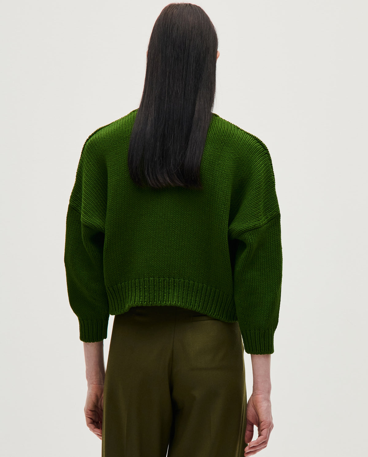 Woman wearing Babaà Jumper No14 Pine, a cozy knit sweater in soft pine green, styled casually for autumn.