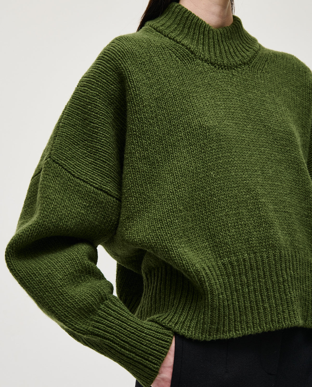 Woman wearing Babaà No15 Forest jumper, featuring a cozy knit design in earthy green tones.