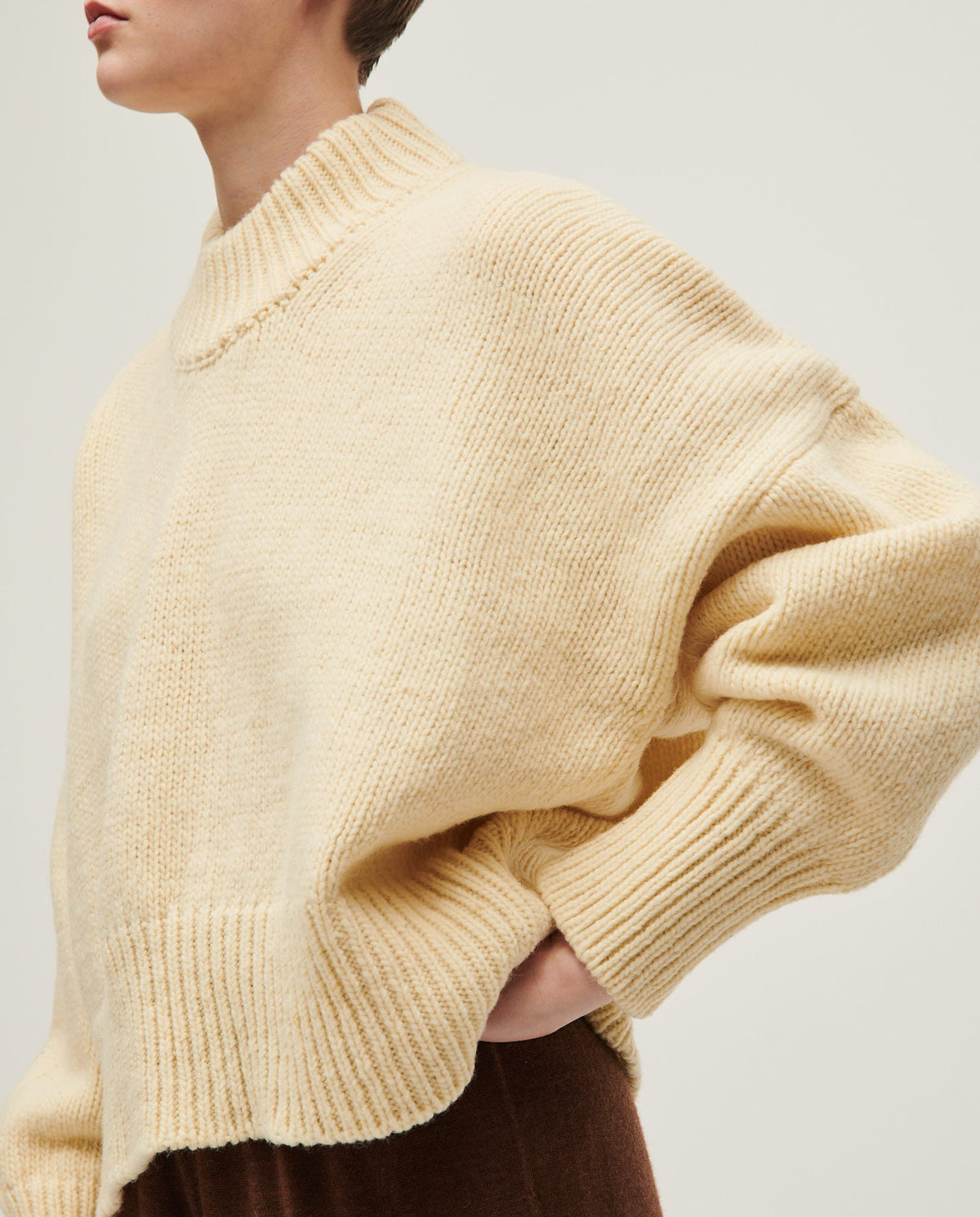 Woman wearing Babaà No15 Natural jumper, showcasing the cozy, soft knit fabric and relaxed fit in a casual setting.