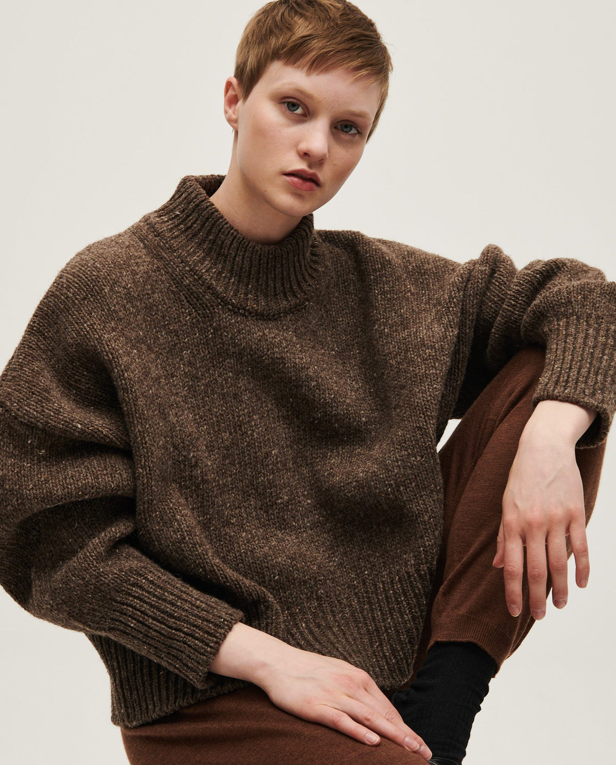 Woman wearing Babaà No15 Oak jumper, featuring a cozy knit design in warm oak color, styled for casual comfort.