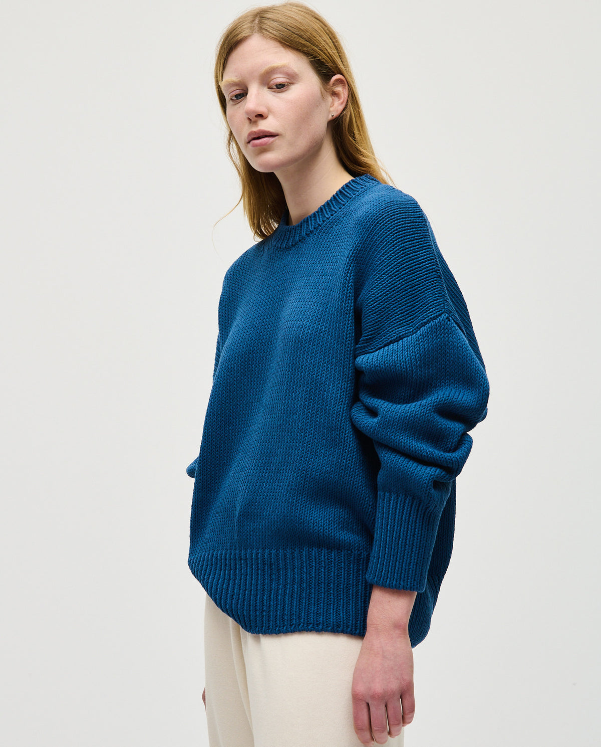 Woman wearing Babaà No16 Deep Water jumper, showcasing a stylish, deep blue knit sweater with a relaxed fit.