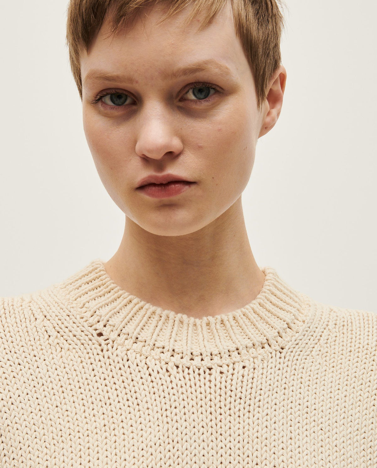 Woman wearing Babaà No16 Natural jumper, cozy knit sweater with a relaxed fit and neutral beige color.