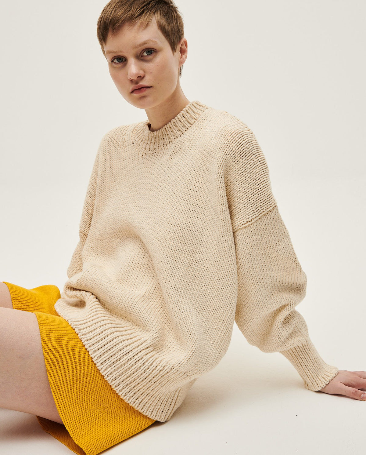 Natural-colored Babaà jumper No16 worn by a woman, showcasing a cozy knit sweater with a relaxed fit.