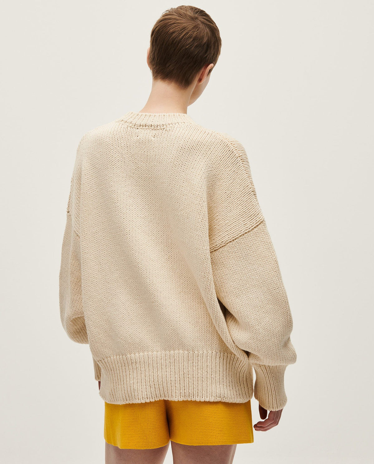 Woman wearing Babaà No16 Natural jumper, showcasing its soft knit fabric and relaxed fit in a casual setting.