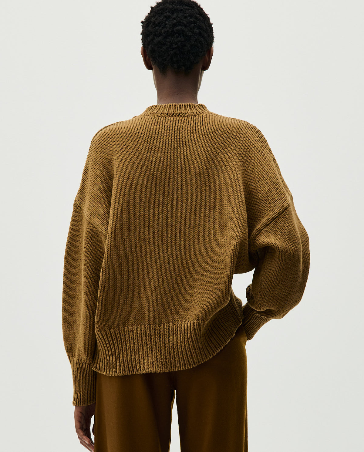 Woman wearing Babaà Jumper No16 Sukkari, cozy knitted sweater in warm Sukkari color with a relaxed fit.