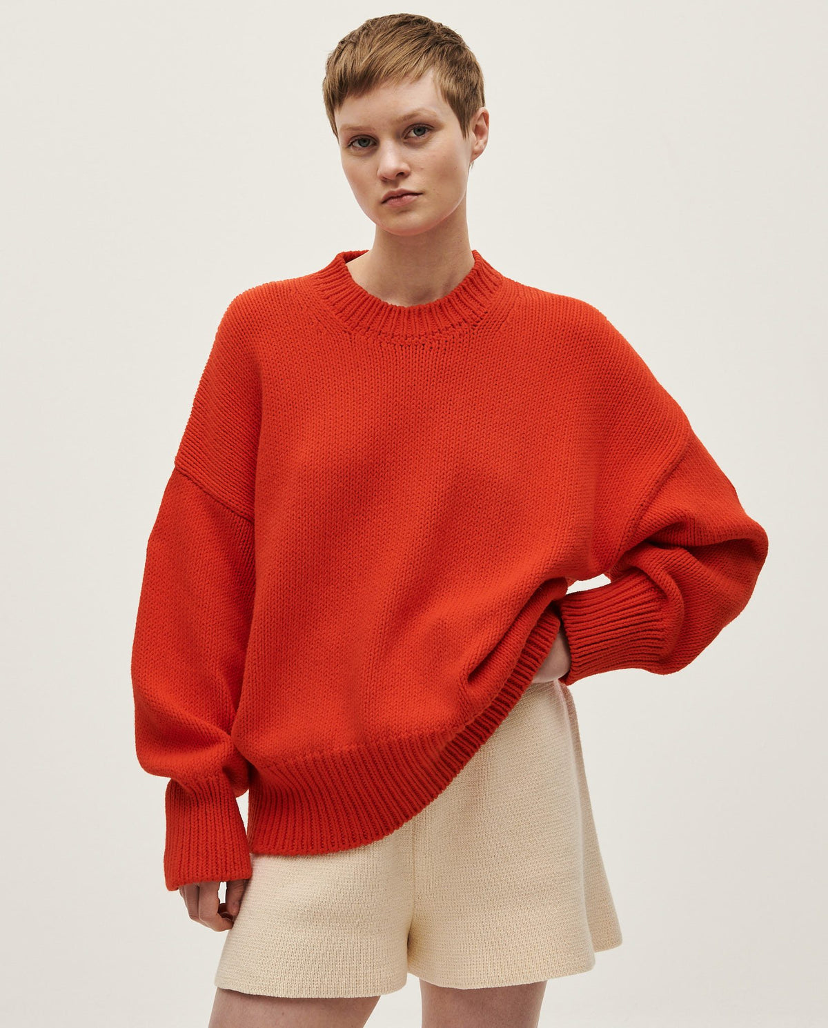 Woman wearing Babaà No16 Summer Flame jumper, featuring a vibrant flame pattern, stylish and lightweight for summer wear.