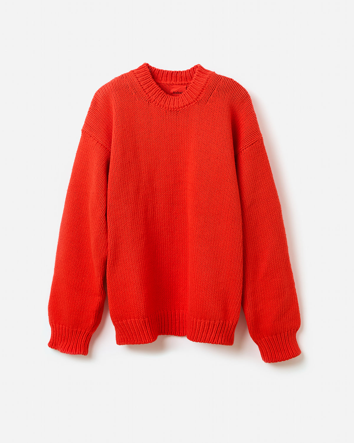 Silhouette of a woman wearing the Babaà No16 Summer Flame jumper, showcasing its relaxed fit and vibrant flame color.