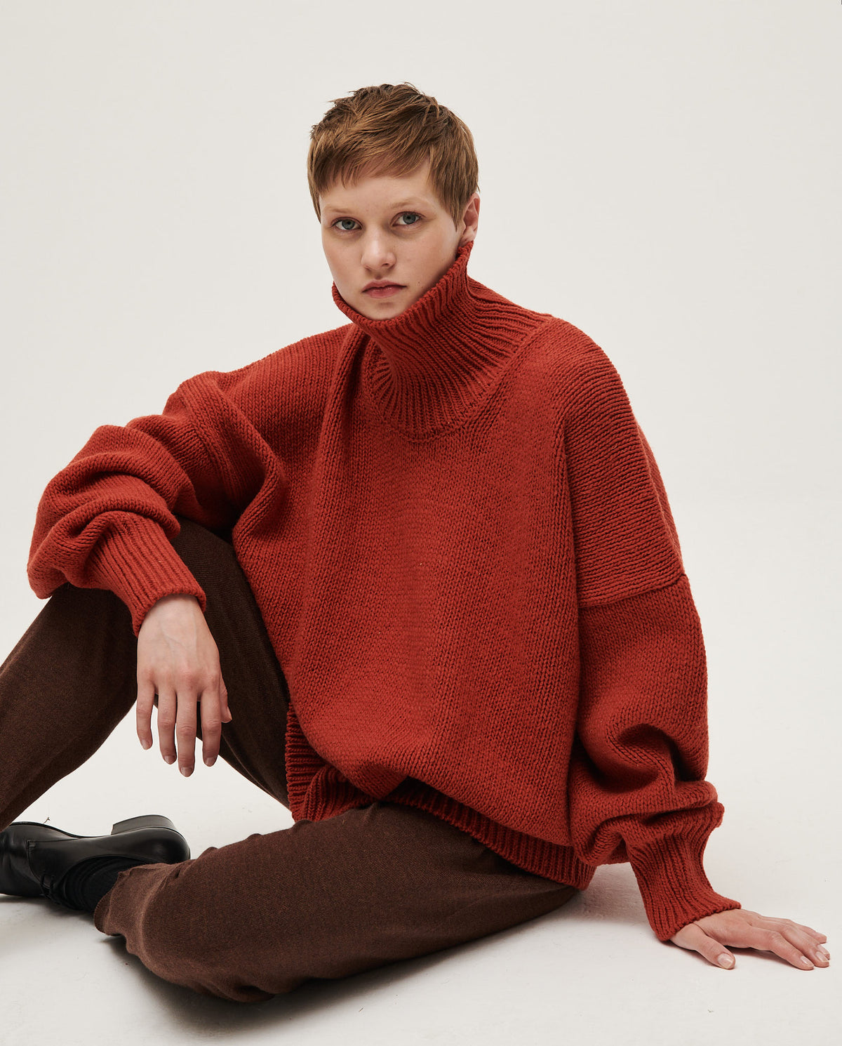 Woman wearing Babaà No17 Arce jumper, showcasing the cozy, knitted design in a natural setting.