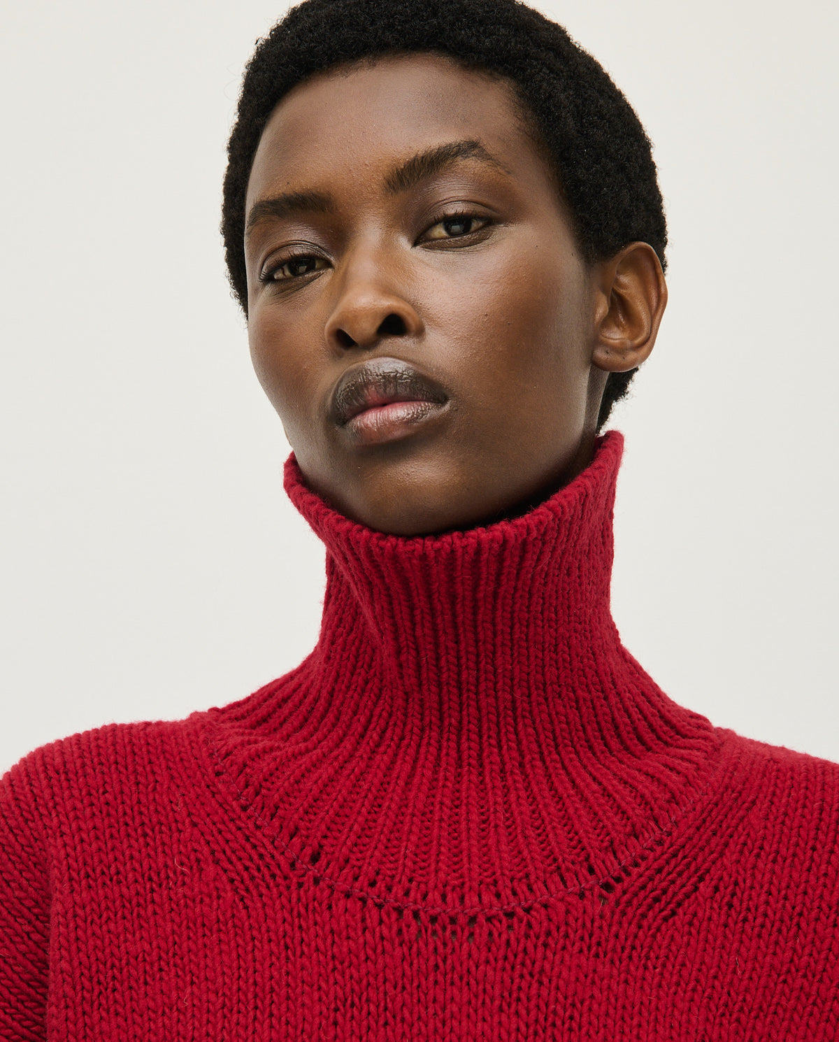 Woman wearing Babaà No17 Cereza jumper, showcasing the stylish red knit sweater with a cozy fit and ribbed details.