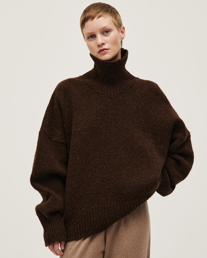 Woman wearing Babaà No17 Earth jumper, featuring a cozy, earthy-toned knitted sweater with a relaxed fit and textured fabric.