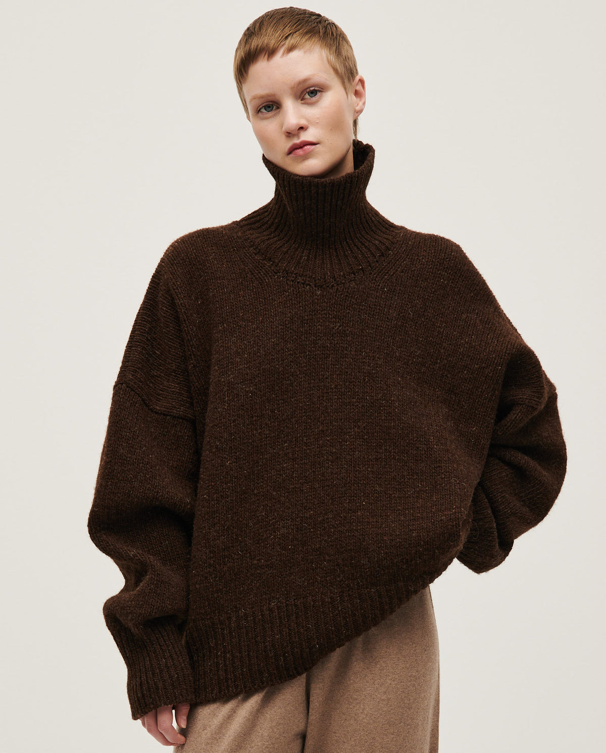 Woman wearing Babaà No17 Earth jumper, featuring a cozy, earthy-toned knitted sweater with a relaxed fit and textured fabric.