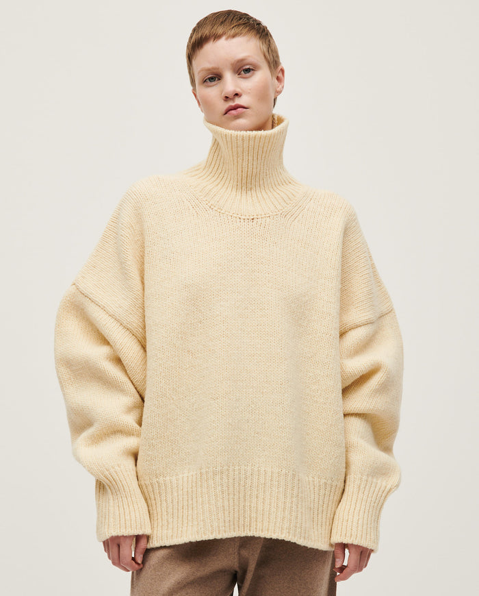 Woman wearing Babaà No17 natural jumper, showcasing a cozy, neutral-colored knit sweater with a relaxed fit and soft texture.
