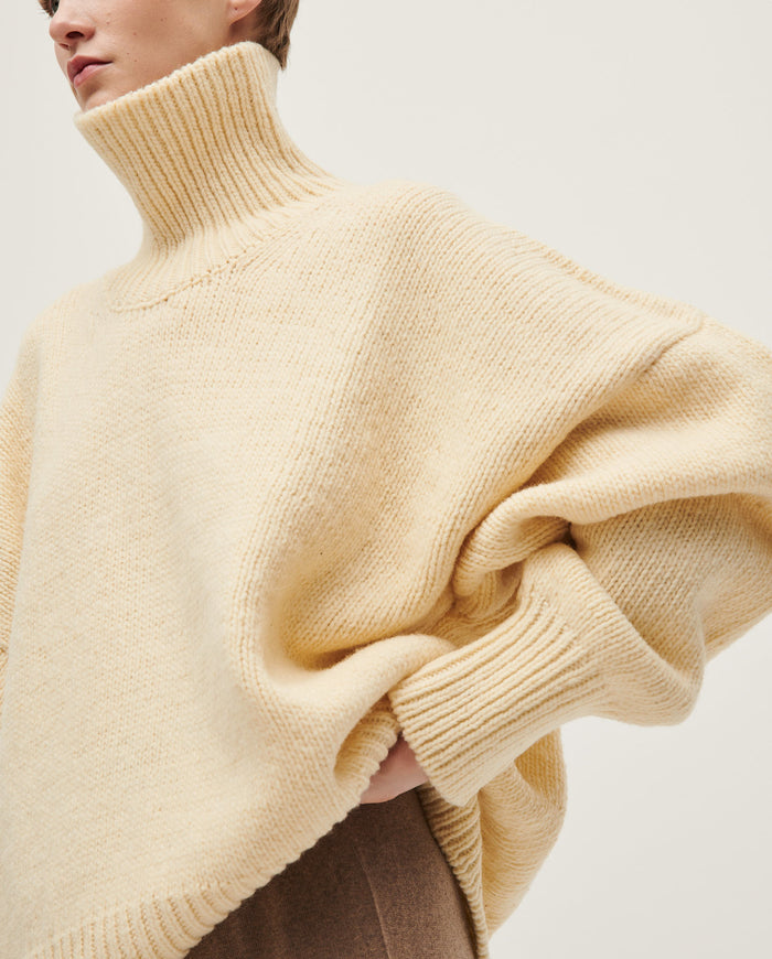 Woman wearing Babaà No17 Natural jumper, showcasing its cozy knit fabric and relaxed fit in a casual setting.