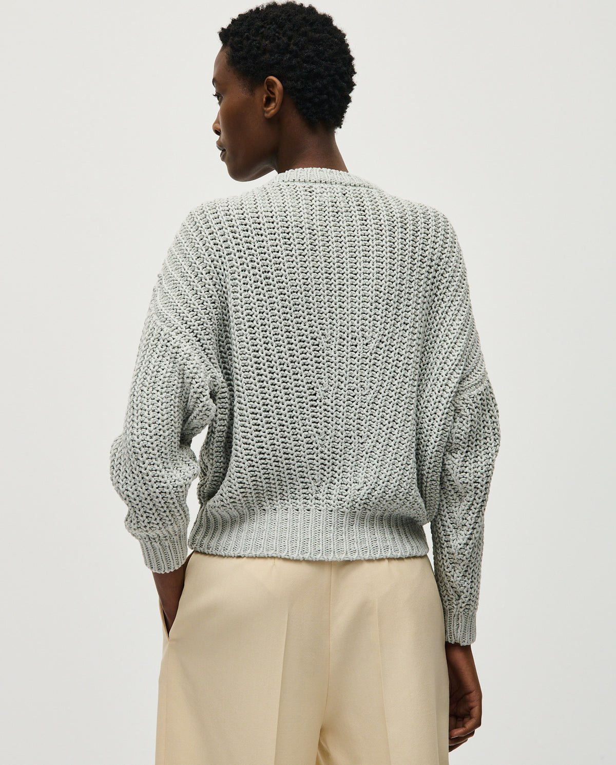 Woman wearing Babaà No18 Chalk jumper, showcasing its comfortable fit and soft fabric in a casual indoor setting.
