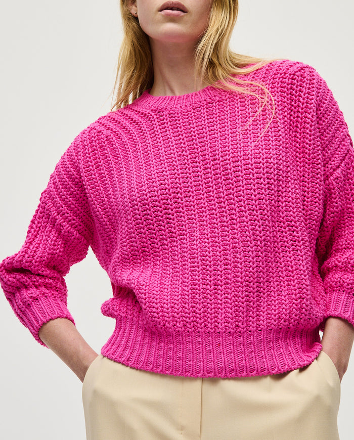 Babaà jumper No18 featuring a vibrant hibiscus flower design worn by a woman, showcasing its colorful and stylish pattern.