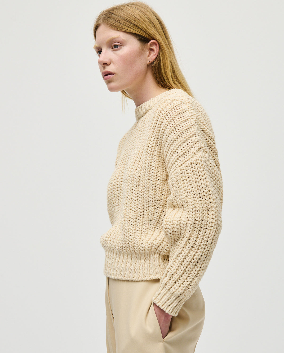Woman wearing Babaà jumper No18 in natural color, showcasing a cozy knit sweater with a relaxed fit and soft texture.