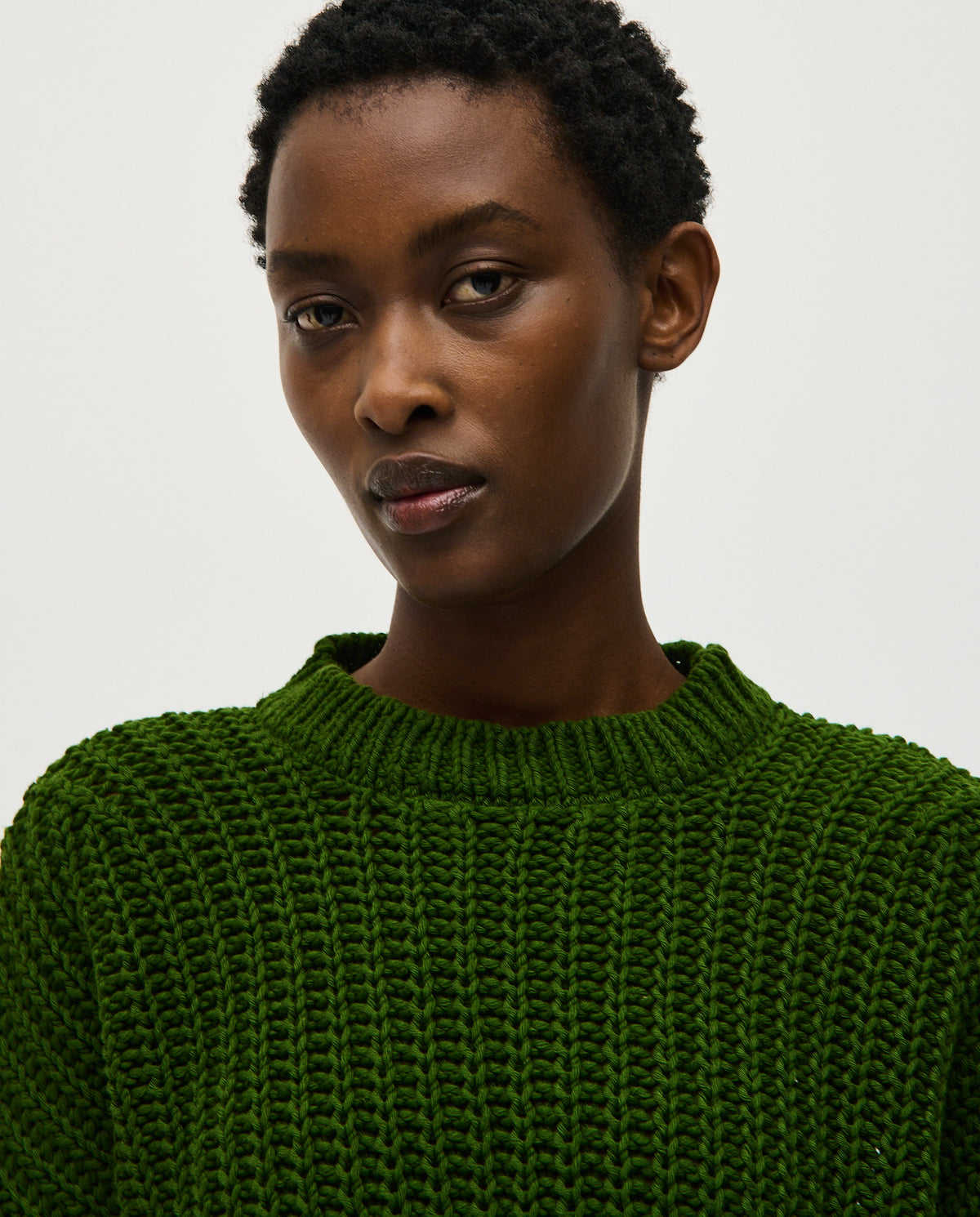 Woman wearing Babaà Jumper No18 Pine, a cozy knitted sweater in green with a relaxed fit and ribbed cuffs.