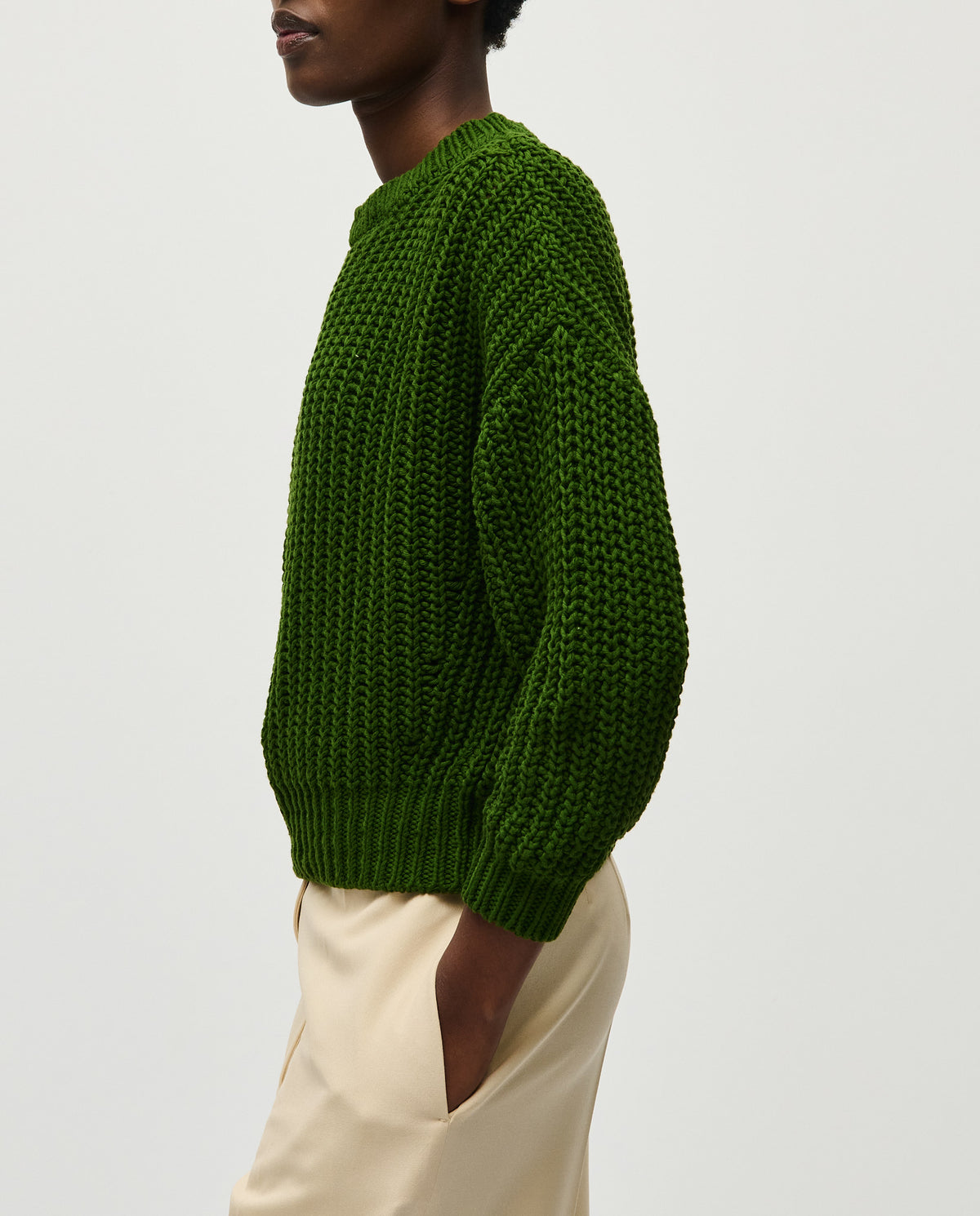 Woman wearing Babaà No18 Pine jumper, showcasing the cozy, knitted sweater in a soft pine green color.