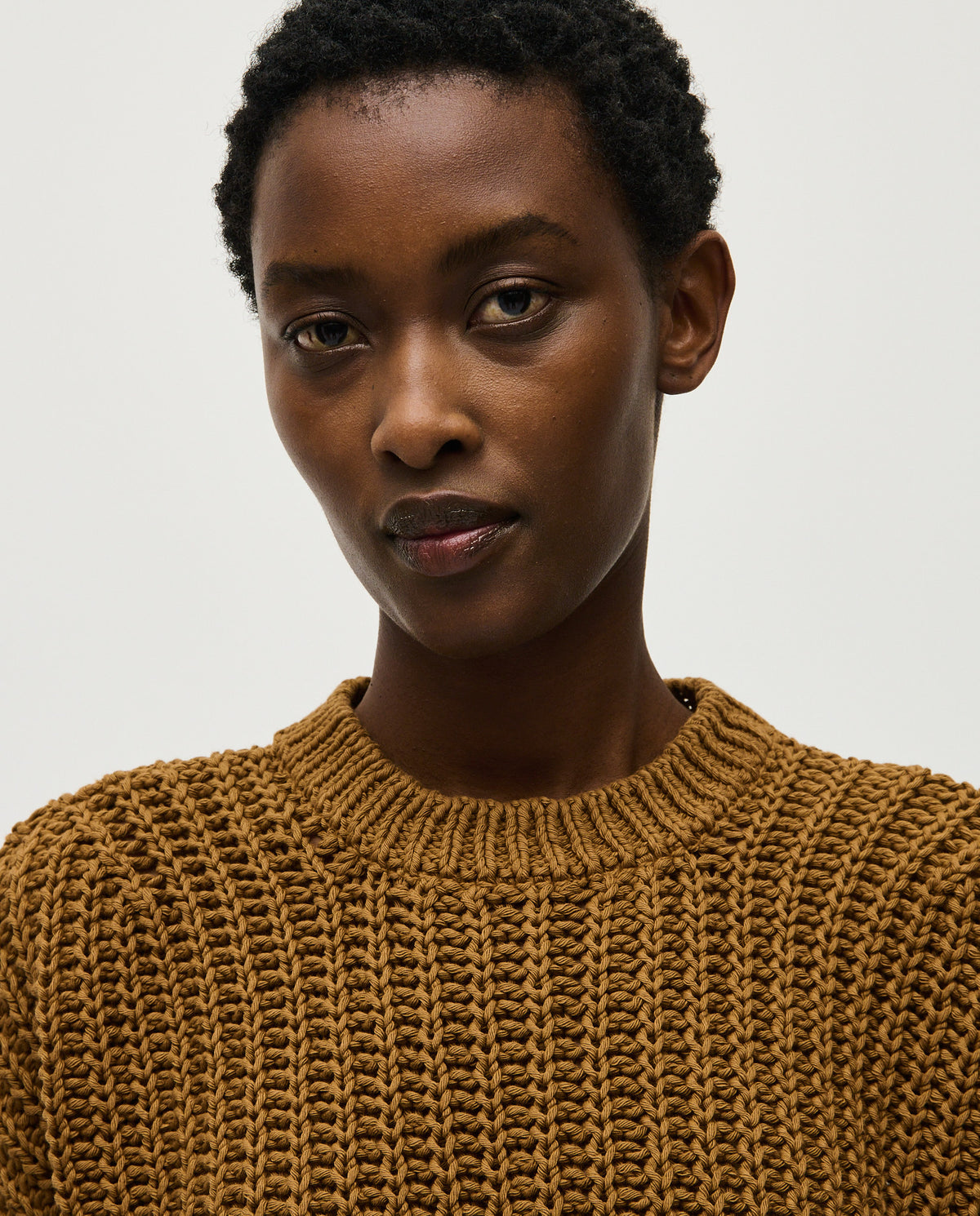 Woman wearing Babaà No18 Sukkari jumper, cozy knit sweater with a relaxed fit, in a warm, earthy tone.