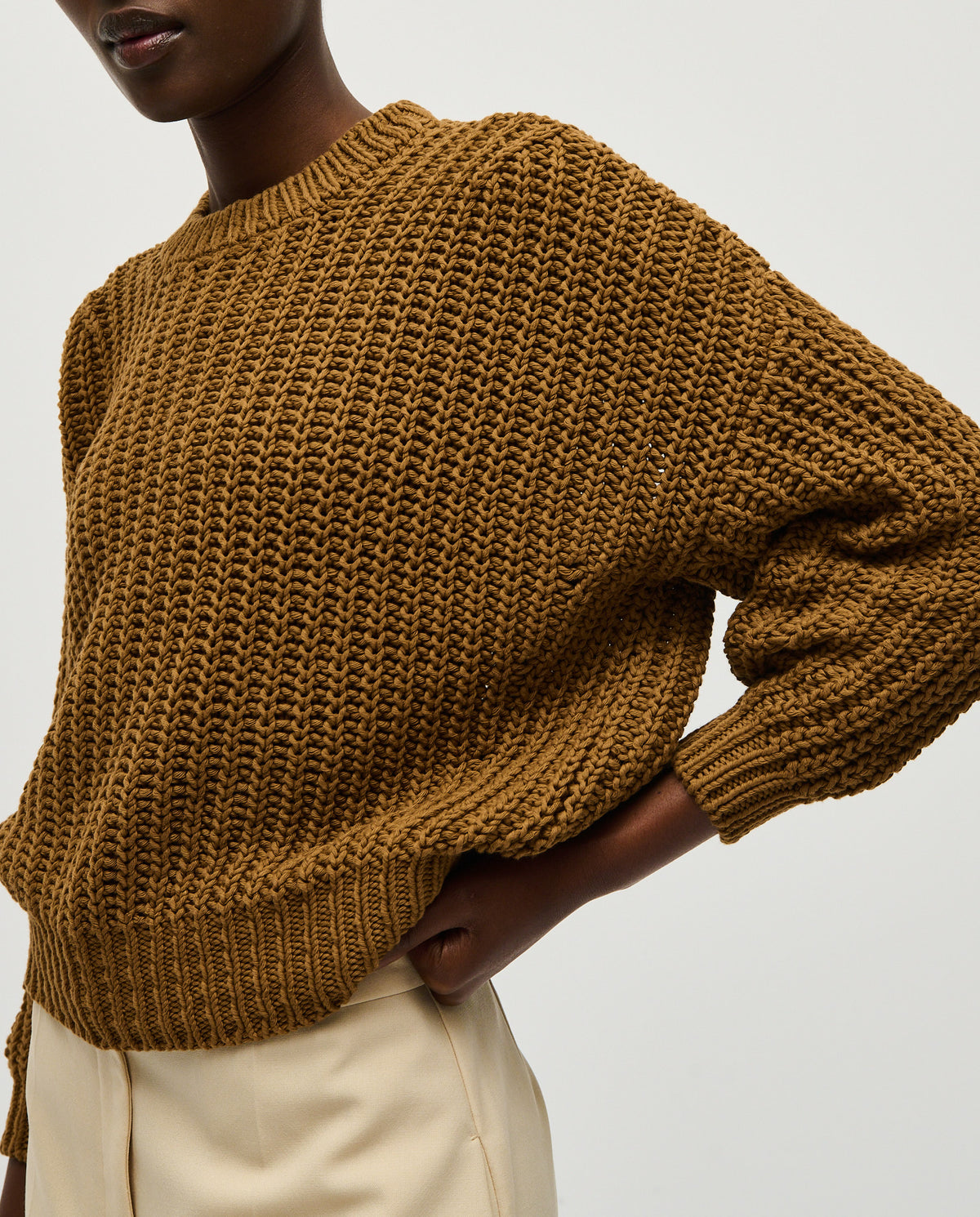 Woman wearing Babaà Jumper No18 Sukkari, cozy knit sweater in earthy tones, styled casually for fall or winter.