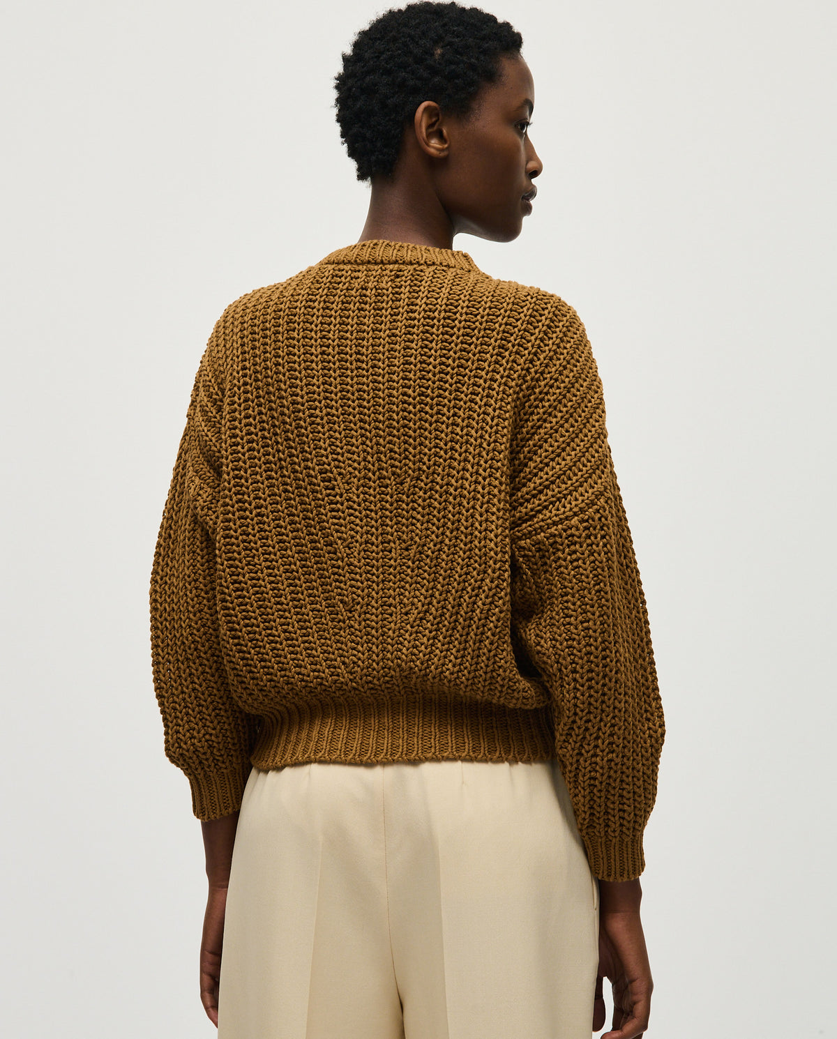 Woman wearing Babaà Jumper No18 Sukkari, cozy knit sweater with a relaxed fit and ribbed cuffs for comfortable style.