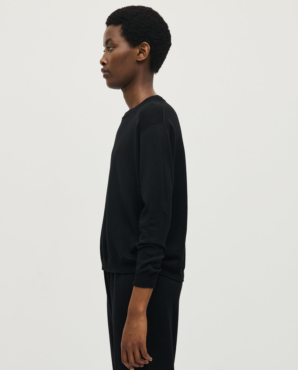 Black Babaà Jumper No25 worn by a woman, showcasing a cozy, stylish knit sweater with a relaxed fit.