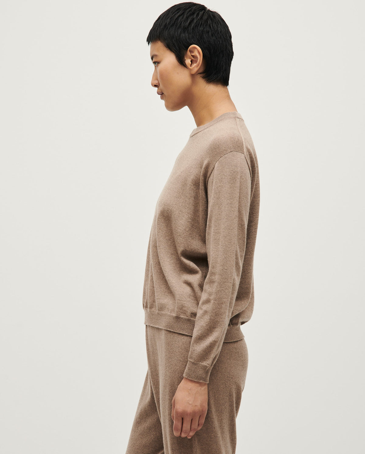 Babaà No25 white gold jumper worn by a woman, showcasing a stylish knit sweater with a relaxed fit and textured fabric.