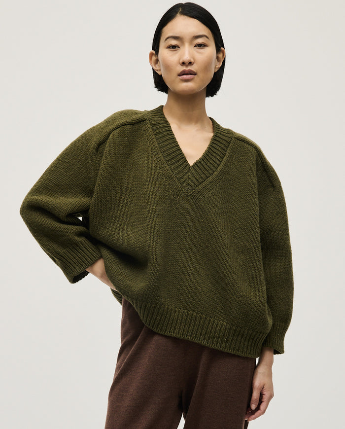 Woman wearing Babaà No29 Alga jumper, showcasing its cozy knit fabric and stylish fit in a casual setting.