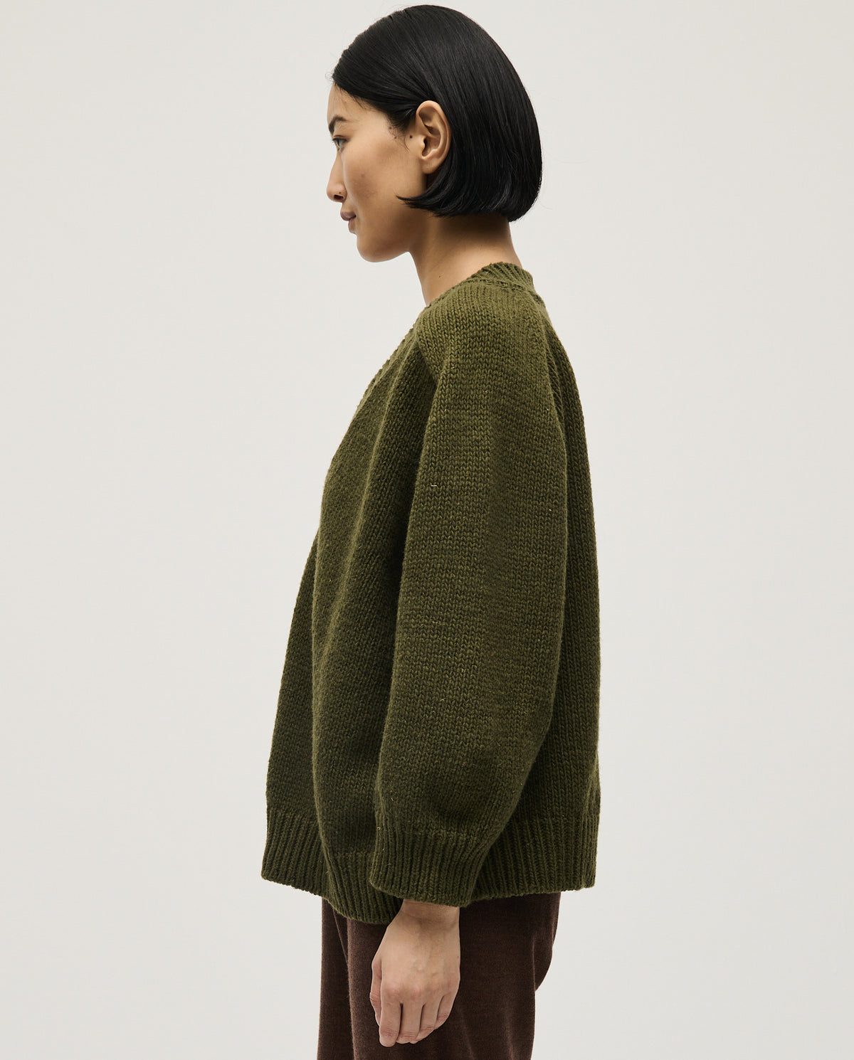 Woman wearing Babaà No29 Alga jumper, showcasing the soft knit fabric and relaxed fit in a stylish casual look.