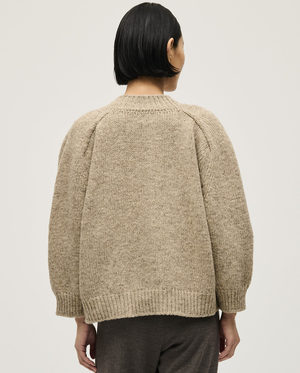 Woman wearing Babaà No29 Mist jumper, showcasing its soft fabric and relaxed fit in a casual indoor setting.